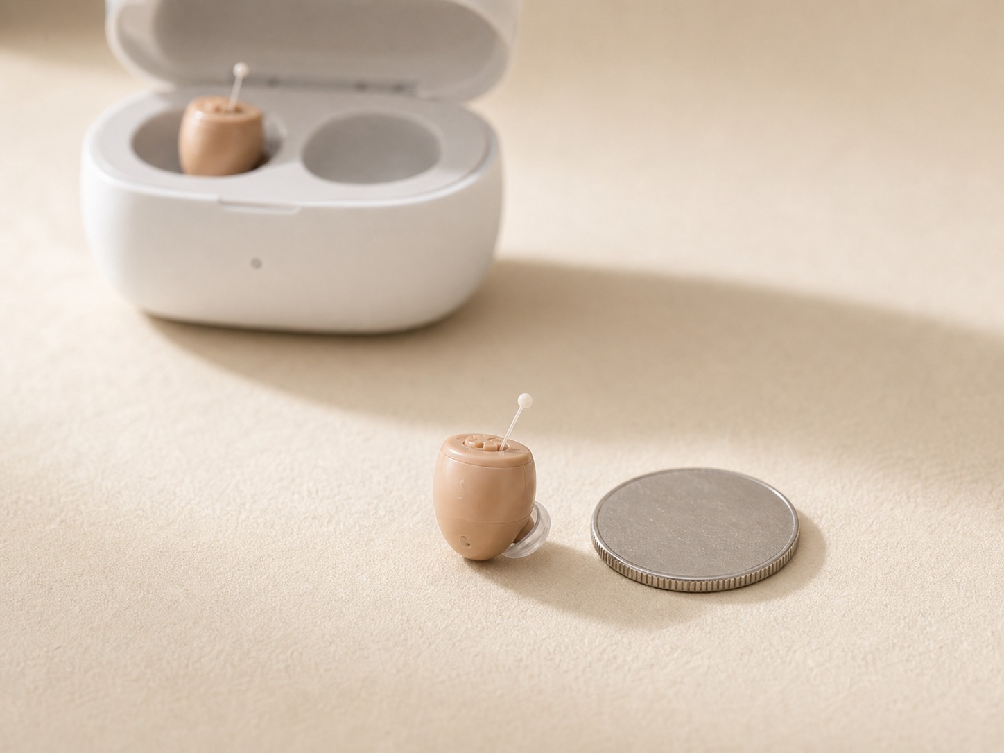 Cost Plus Invisible Hearing Aid next to a coin for scale